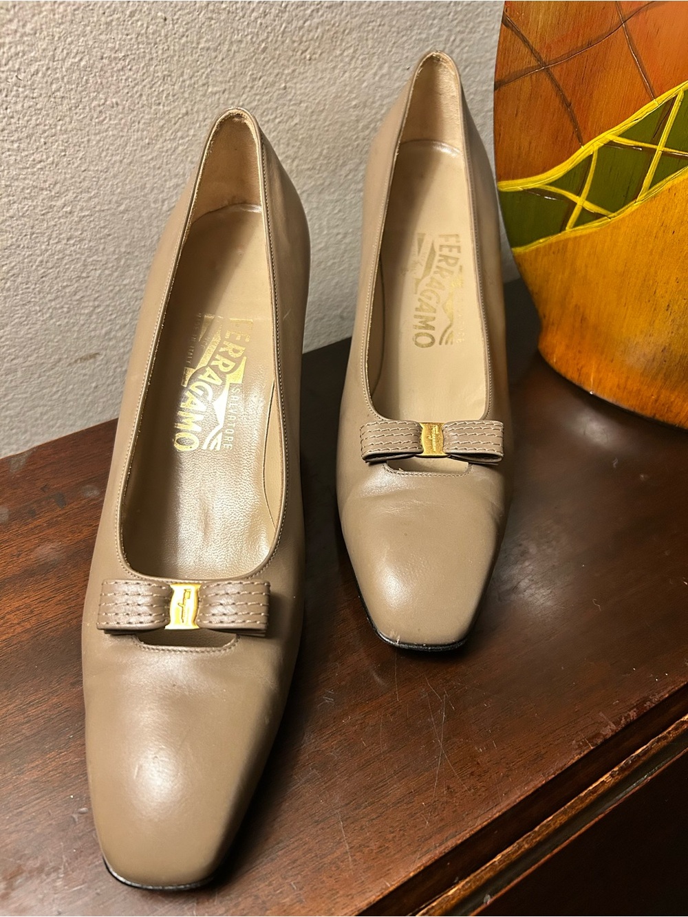 Salvatore Ferragamo Beige Leather Bow Pumps with Gold Accent.